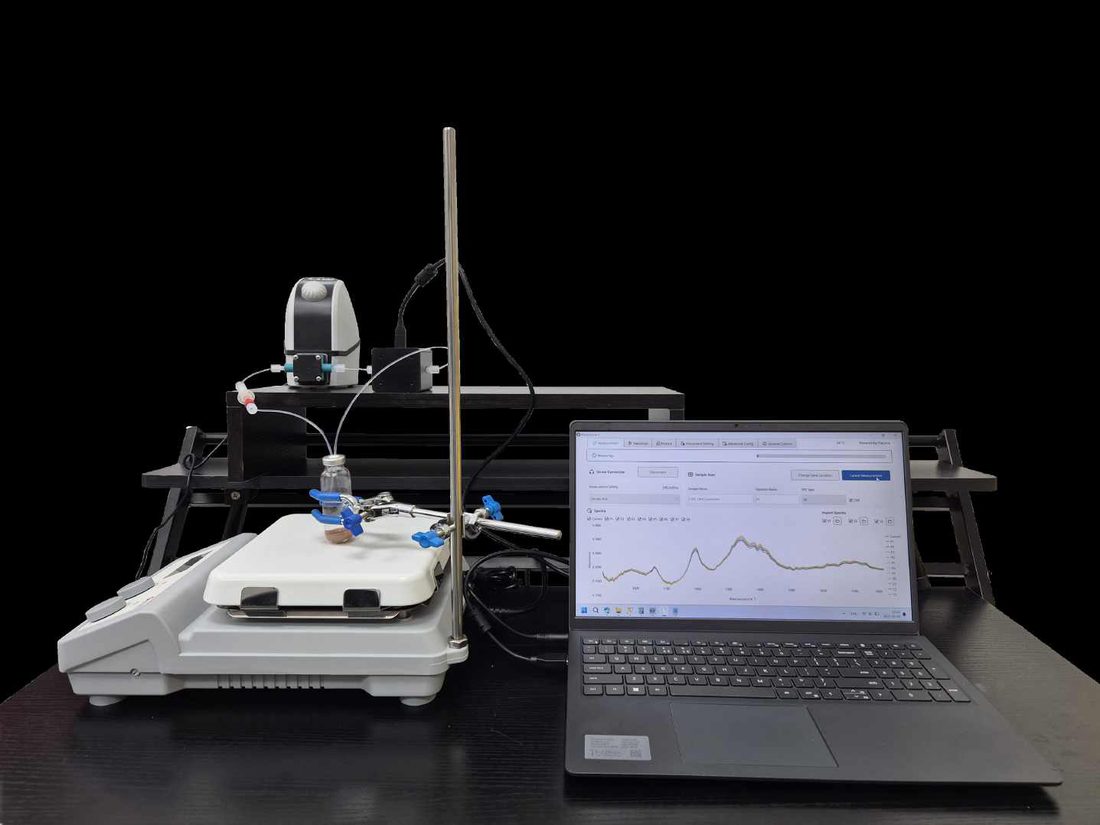 Réacteur de laboratoire agité, boucle de recirculation traversant une cellule de transmission moyen infrarouge, spectres affichés en direct sur un ordinateur portable